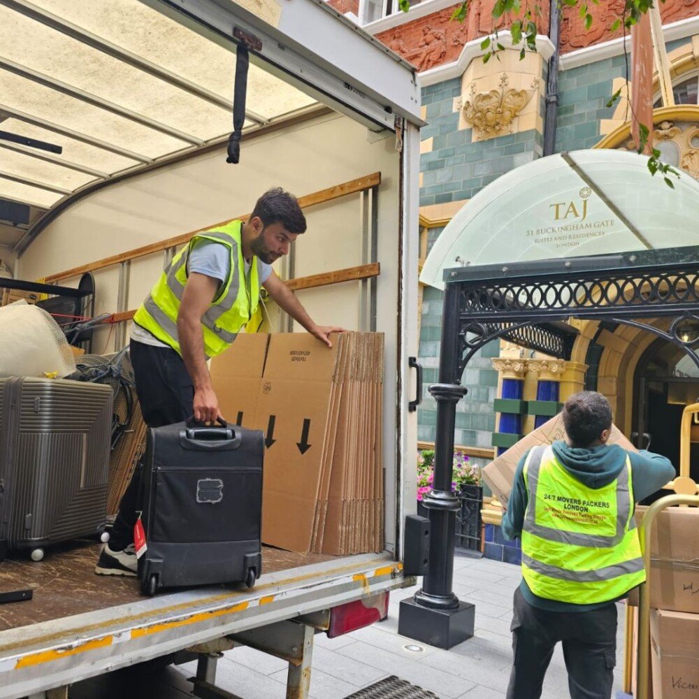 Two movers are lifting things from a moving van.