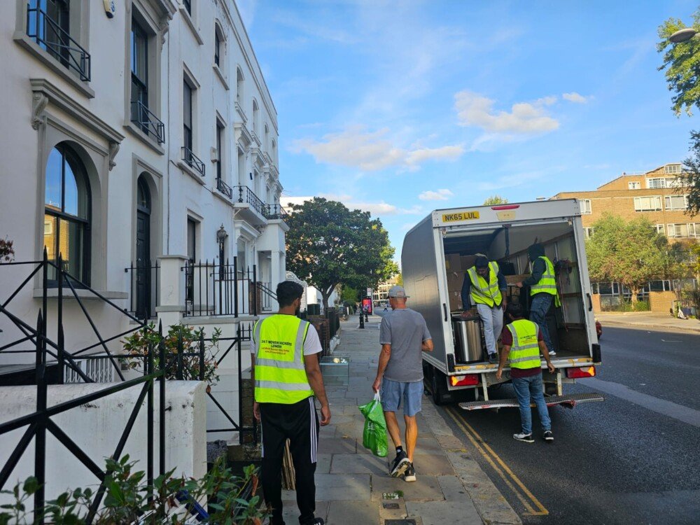 Professional moving company team packing and labeling cardboard boxes for residential removals and storage services in London.